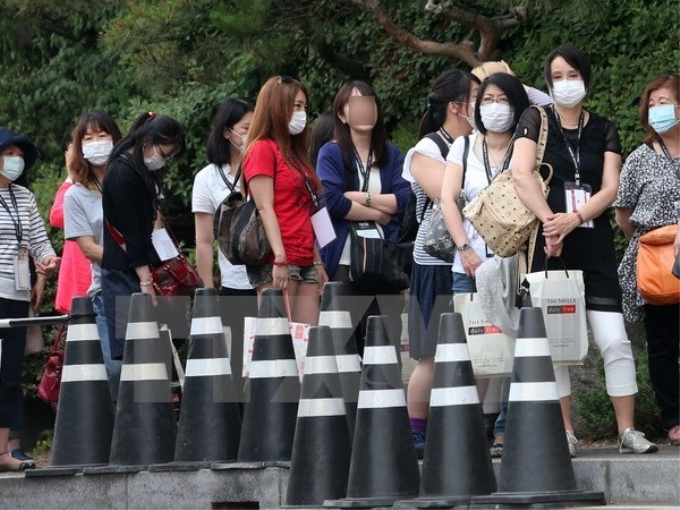 Khách du lịch tại thủ đô Seoul, Hàn Quốc đeo khẩu trang để phòng tránh lây nhiễm MERS ngày 13/6. (Nguồn: Yonhap/TTXVN)